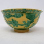 A Chinese yellow ground bowl, decorated figures and foliage in green enamel, 15 cm diameter good