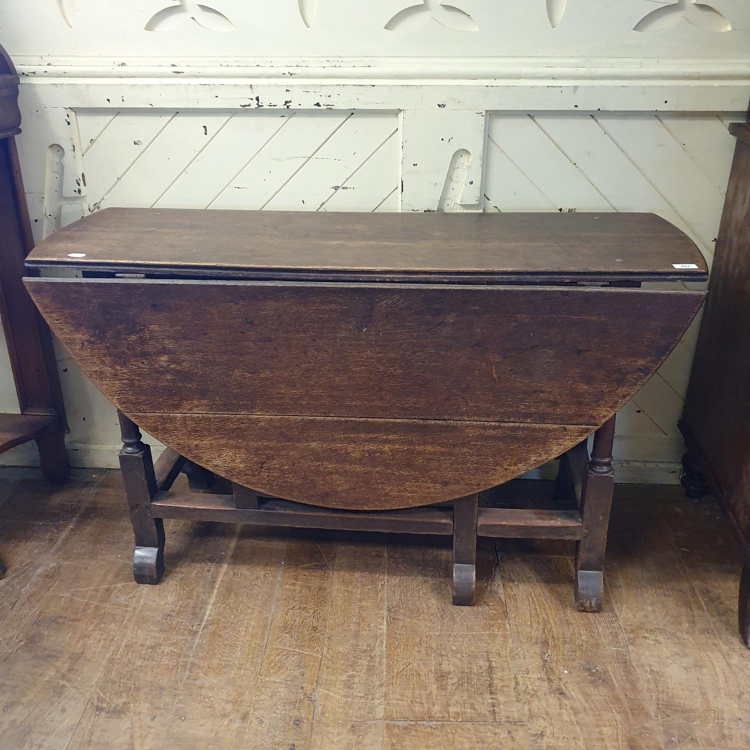 An 18th century oak gateleg table, on barley twist legs joined by stretchers, 134 cm wide