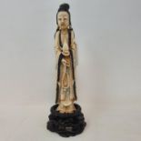 An early 20th century Chinese carved, stained and painted ivory figure, of a lady holding beads