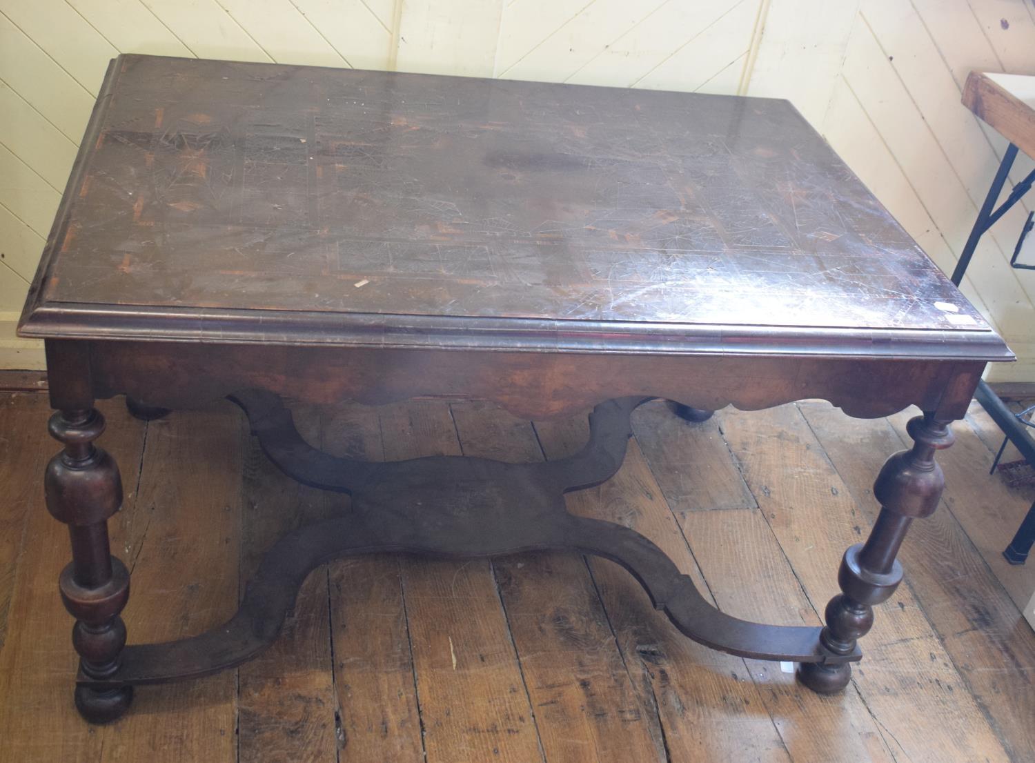 A 17th century style table, with oyster cut veneer, on turned legs joined by a shaped X stretcher,