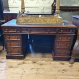 A mahogany pedestal desk, the leatherette inset top above an arrangement of nine drawers, 132 cm