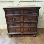 An early 18th century style oak chest, of small proportions, having four long drawers, on bun