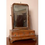 An 18th century walnut dressing mirror, with cable inlay, the box base with three drawers, on ogee