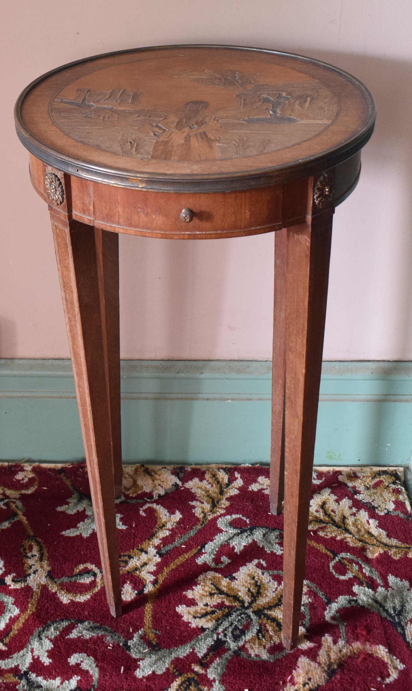 A French occasional table, the top inlaid a lady with a castle in the distance, above a frieze
