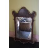 An 18th century style wall mirror, veneered in yew and with parcel gilt decoration, 58 cm wide x 102