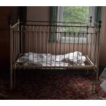 A late Victorian/Edwardian child's painted metal and brass cot, lacks a rod section, 142 x 86 cm,