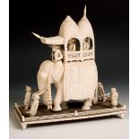 A late 19th century carved ivory elephant, carrying a howdah, carrying two figures escorted by