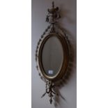 A pair of Victorian gilt gesso oval wall mirrors, decorated flowers and foliage and surmounted