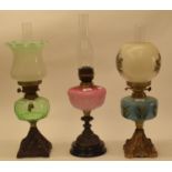 A late 19th/early 20th century spelter oil lamp, with green glass shade, and five others (6)