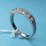 A diamond half hoop ring in a white coloured metal setting