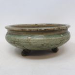 A Chinese green crackle glazed Song dynasty style pottery bowl, with incised decoration, on three