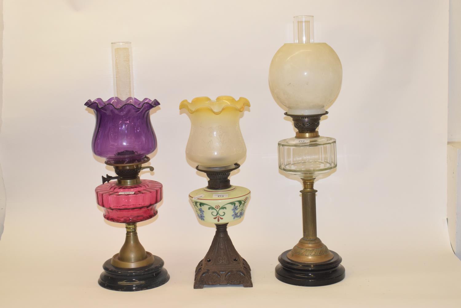 A late 19th/early 20th century glass oil lamp, with clear glass well, and five others (6)