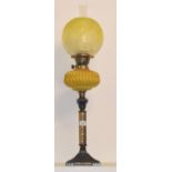 A late 19th/early 20th century oil lamp, with a yellow glass well, 78 cm high Shallow chips to