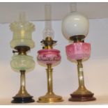 A late 19th/early 20th century brass and glass oil lamp, with pink glass well, and eight others (