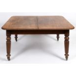 An early 19th century mahogany extending dining table, inset three extra leaves, on tapering