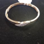 A yellow gold and diamond crossover type bangle