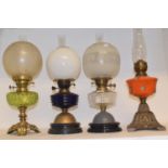 A late 19th/early 20th century spelter oil lamp, with blue glass well, and six others (7)