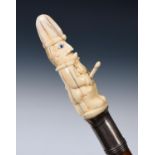 A 19th century malacca walking stick, with a carved ivory handle, in the form of a risque Mr Punch