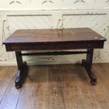 An early Victorian rosewood library table, with two frieze drawers, on end supports joined by a
