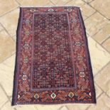 A Persian blue ground rug, main red border centre, with repeating geometric forms, 153 x 105 cm