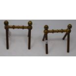 A pair of late 19th century Arts and Crafts brass fire dogs, with turned finials and turned