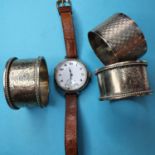 A gentleman's silver wristwatch, and three silver napkin rings (4)
