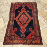 A Persian blue ground rug, main brown border, centre with repeating stepped lozenges, 201 x 124 cm