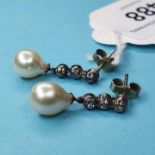 A pair of earrings, with a cultured pearl suspended below three diamonds