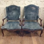 A pair of French upholstered armchairs, with rococo style carved decoration (2)