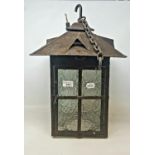 An Arts and Crafts style lantern, with a wrought iron bracket, a wall hanging oil lamp, and two