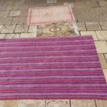 A pink ground carpet with horizontal strip decoration, 180 x 294 cm, and three other rugs, (4)