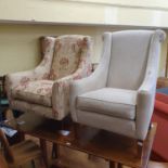 A modern cream armchair, another in floral fabric and two low tables