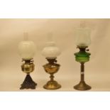 A late 19th/early 20th century brass oil lamp, and five others (6) Green font with hairline crack,