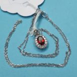 An 18ct white gold, garnet and diamond pendant necklace, approx. 75 points