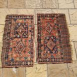 A pair of red ground Persian rugs, both with main blue border, centre with two square medallions,