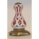 A 19th century cased red and white glass oil lamp base, with gilt metal mounts, raised on lion paw