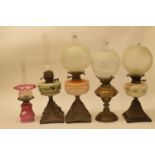 A late 19th/early 20th century brass oil lamp, with engraved glass shade, and eleven others (12)