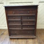 An oak chest, of small proportions, having an arrangement of one long, six short, and a further long