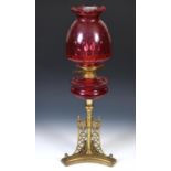 A late 19th/early 20th century brass oil lamp with ruby glass well, 70 cm Shallow chips to base of