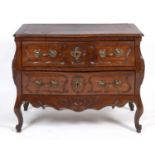 A late 18th/early 19th century French walnut bombe commode, having two drawers, on carved cabriole