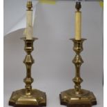 A pair of brass candlesticks, adapted to lamps, 52 cm high (over fitments), two elm bellows and