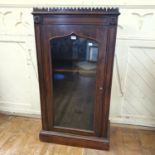 A Victorian rosewood pier style cabinet, the ogee shaped door with a glass panel, on a plinth