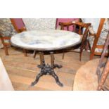 A 19th century ebonised oval table, with a marble top, on four pillar support to splay legs, 70 x 89