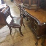 An early 20th century mahogany serpentine desk, with five drawers, on carved cabriole legs with ball