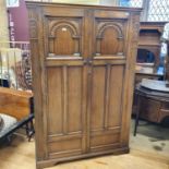 An oak wardrobe, with carved panel doors