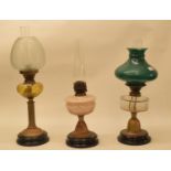 A late 19th/early 20th century brass oil lamp, with clear glass well, and five others (6)