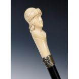 A 19th century ebonised walking cane, with carved ivory handle, in the form of a soldier, with