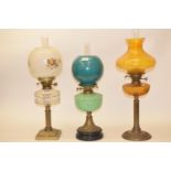 A late 19th/early 20th century brass oil lamp, with green glass well, and five others (6)