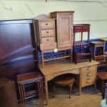 An early 20th century nest of tables, a kneehole desk, mahogany bookcase, pine pot cupboard, and