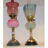 A late 19th/early 20th century oil lamp with pink glass well, 68 cm high, and another (2) Both